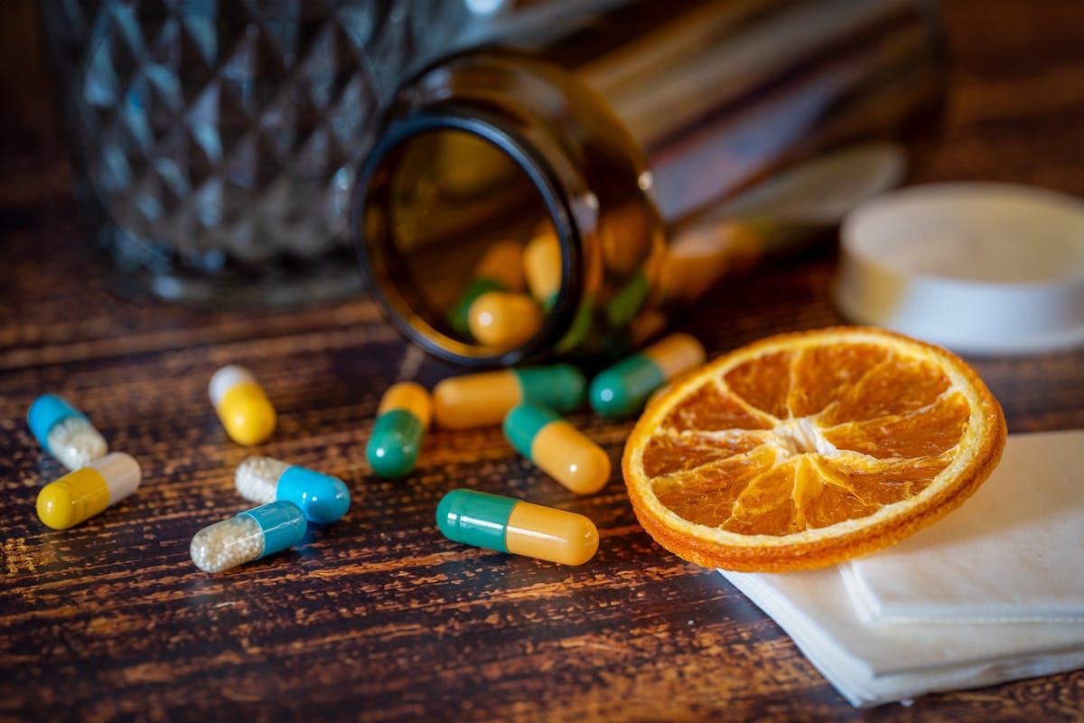 NMN supplements spilling out of a tipped glass bottle