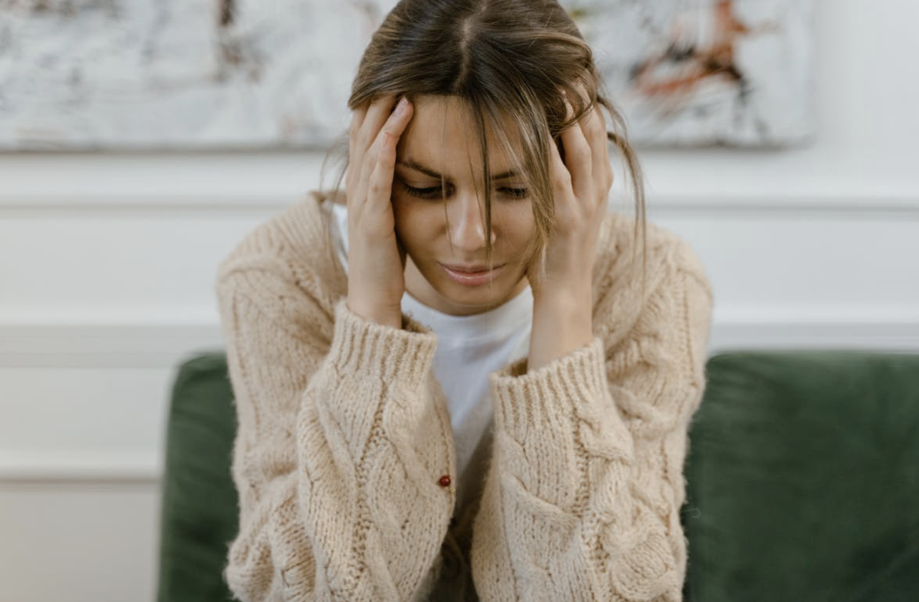 woman with her head in her hands looking stressed