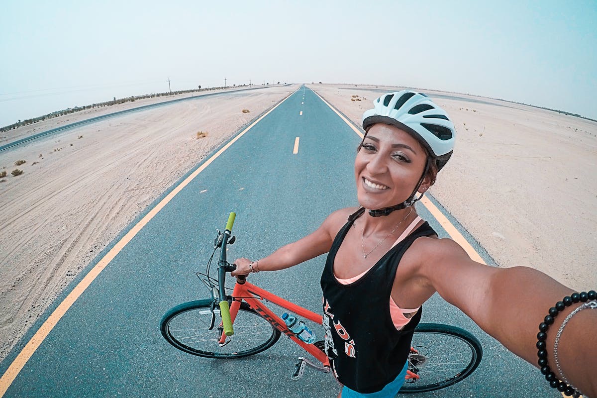 woman on a road bike takes an overhead selfie during a ride