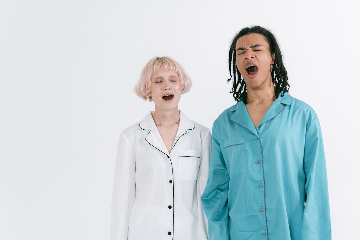 sleepy couple both yawning as they figure out which supplement - 5htp vs melatonin-- is right to address their sleep problems