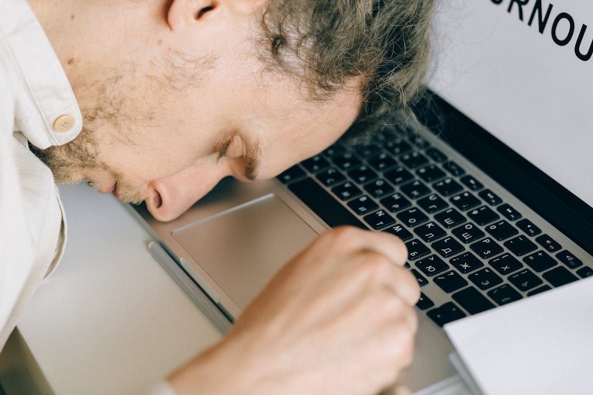 man asleep on his laptop keyboard