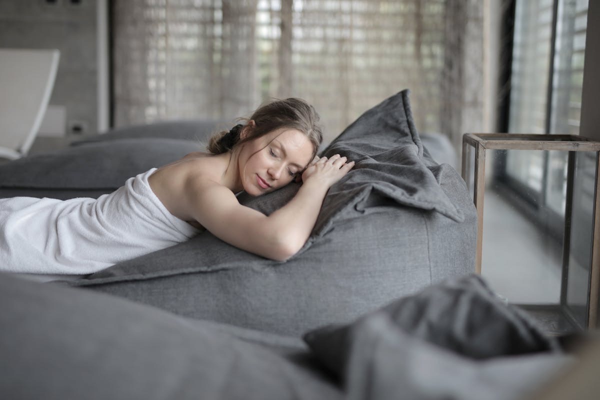 woman lying on a comfortable massage table, looking content and peaceful