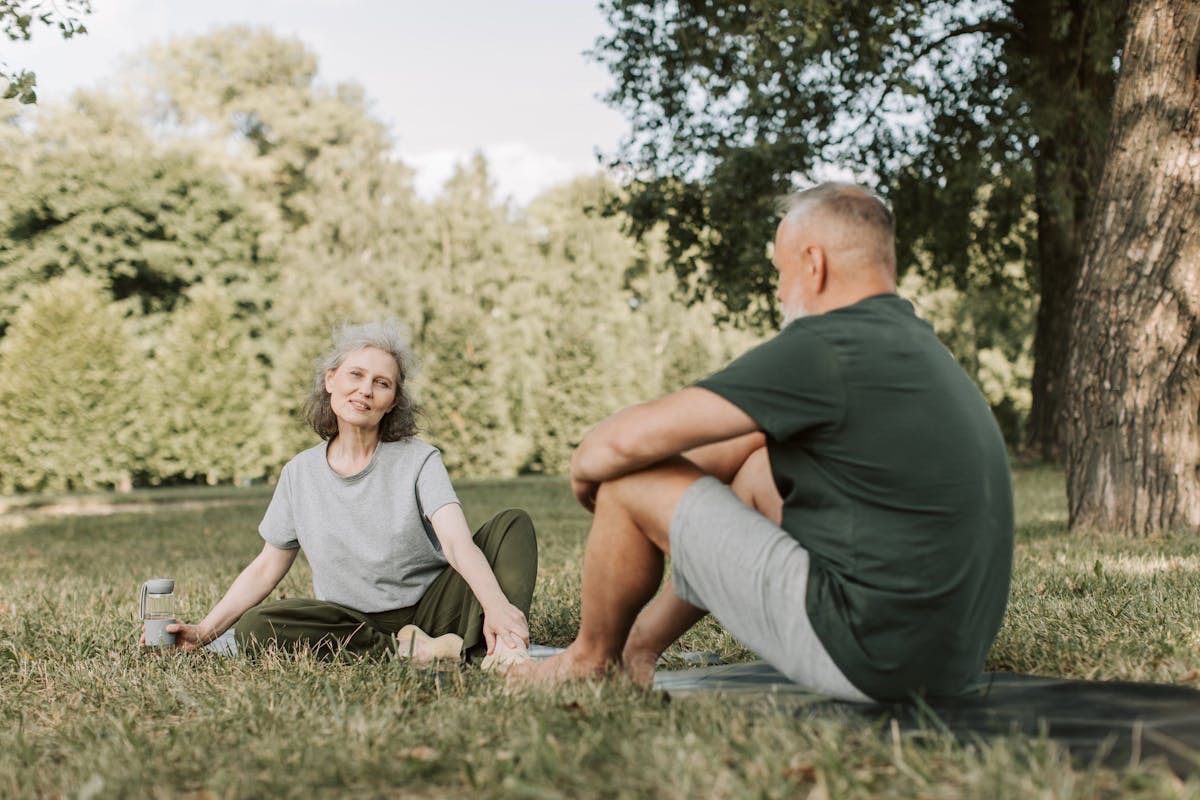 older couple resting in the grass during a hike