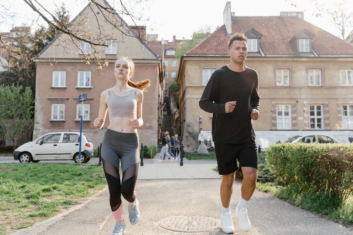 man and woman jogging in a city neighborhood