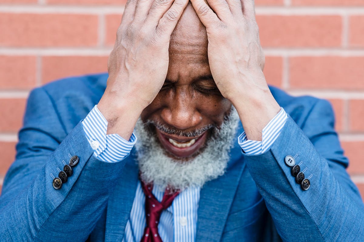 older gentleman in a suit in a posture of extreme anxiety