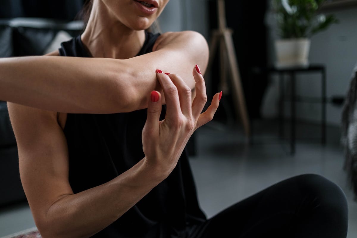 woman in workout clothes stretching her arm across the front of her body