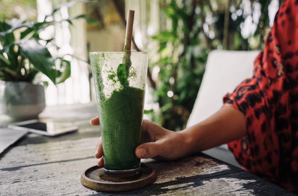 woman with a healthy green collagen smoothie
