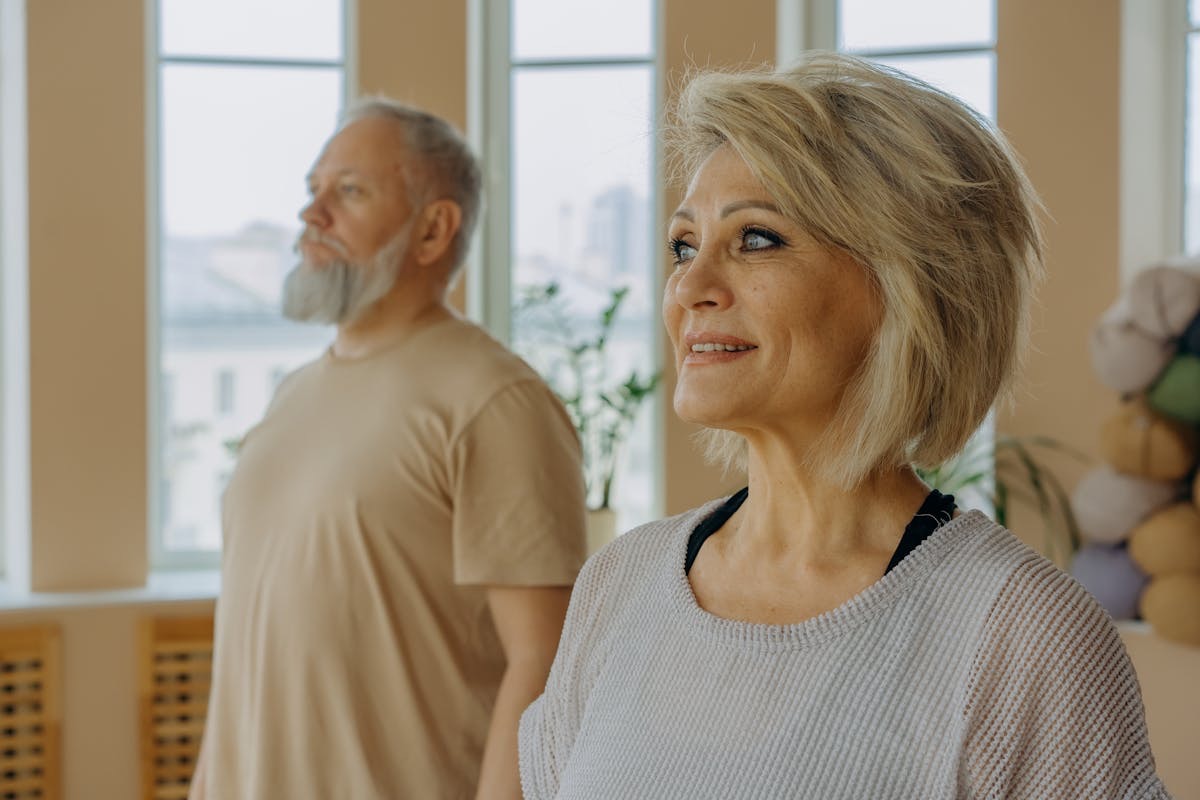 healthy older couple doing yoga together on a warm, bright morning