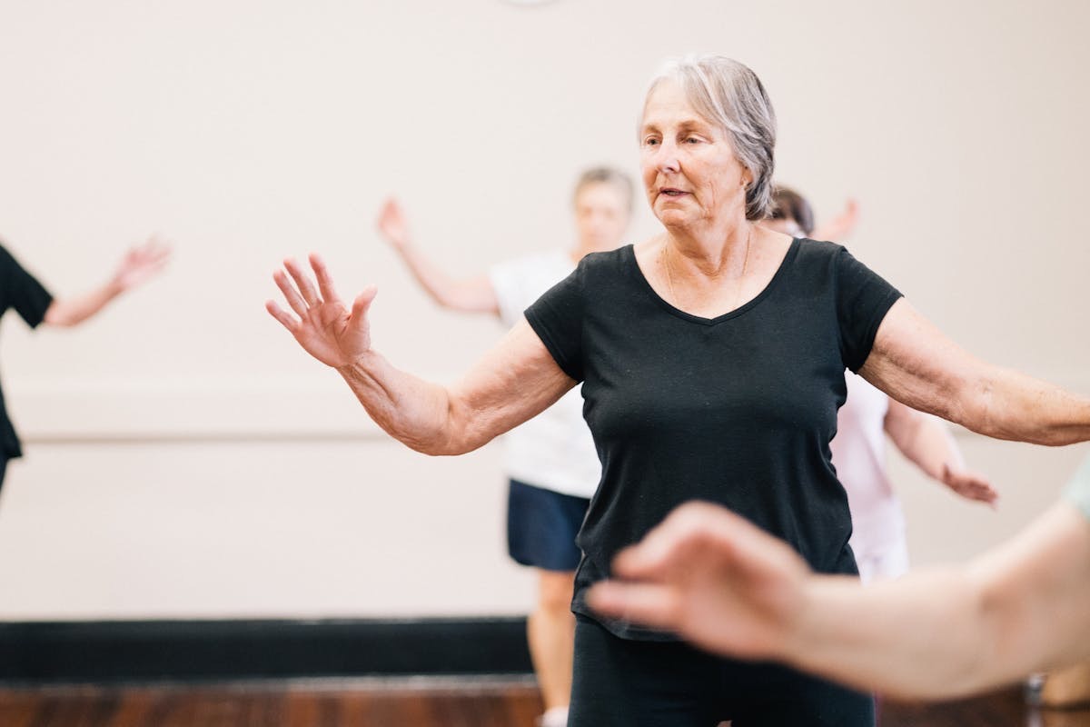 older woman staying active and having fun in a workout dance class thanks to joint support from her collagen supplements