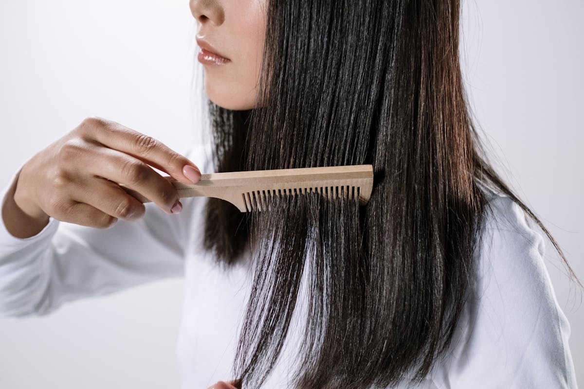 woman combing hr long, healthy brown hair