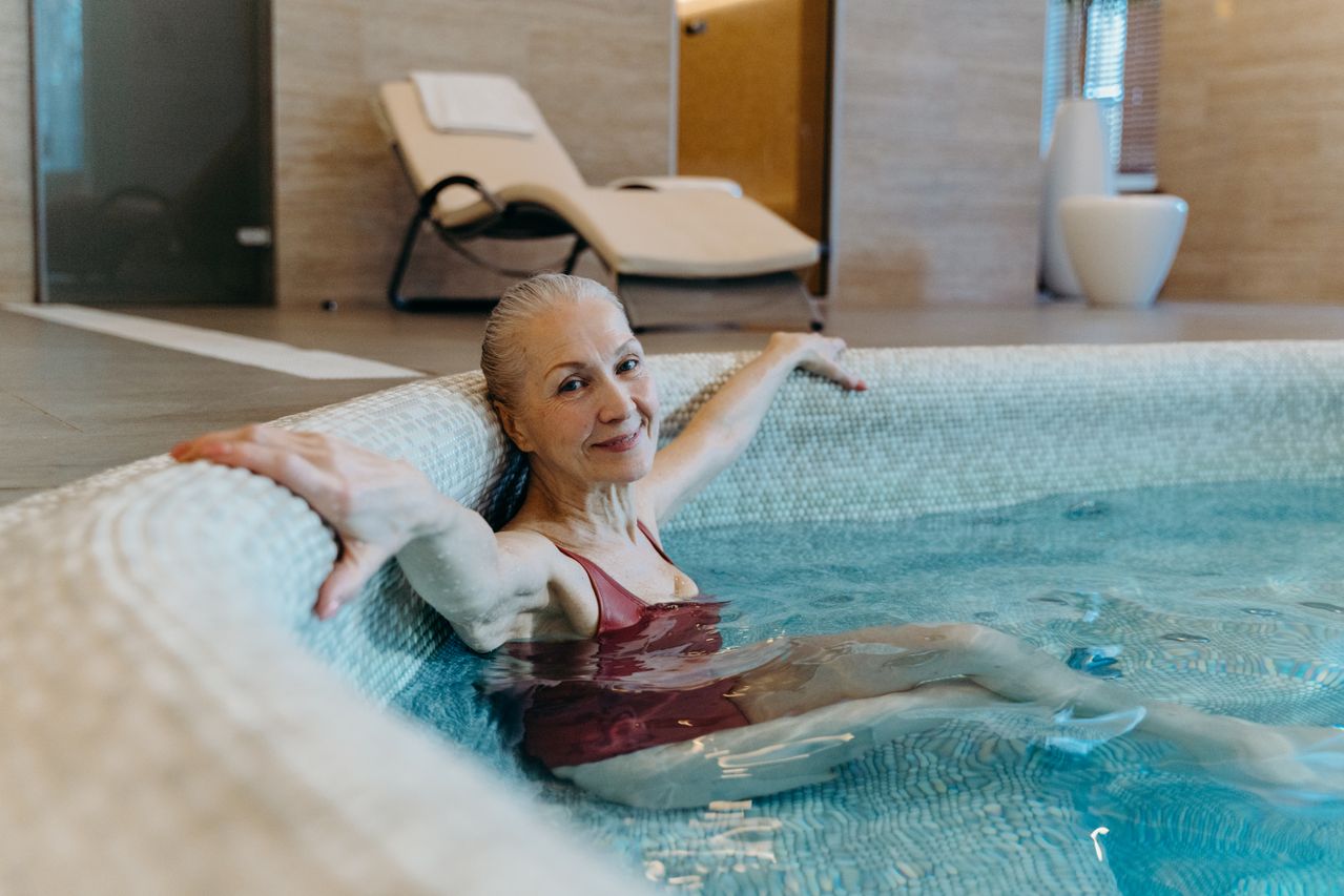 woman prioritizing healthy aging relaxing after a workout in a pool