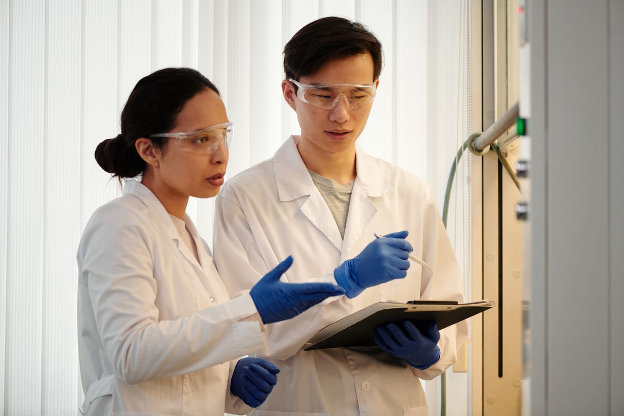 researchers wearing goggles, gloves, and lab coats discussing their findings in the latest NMN clinical trial