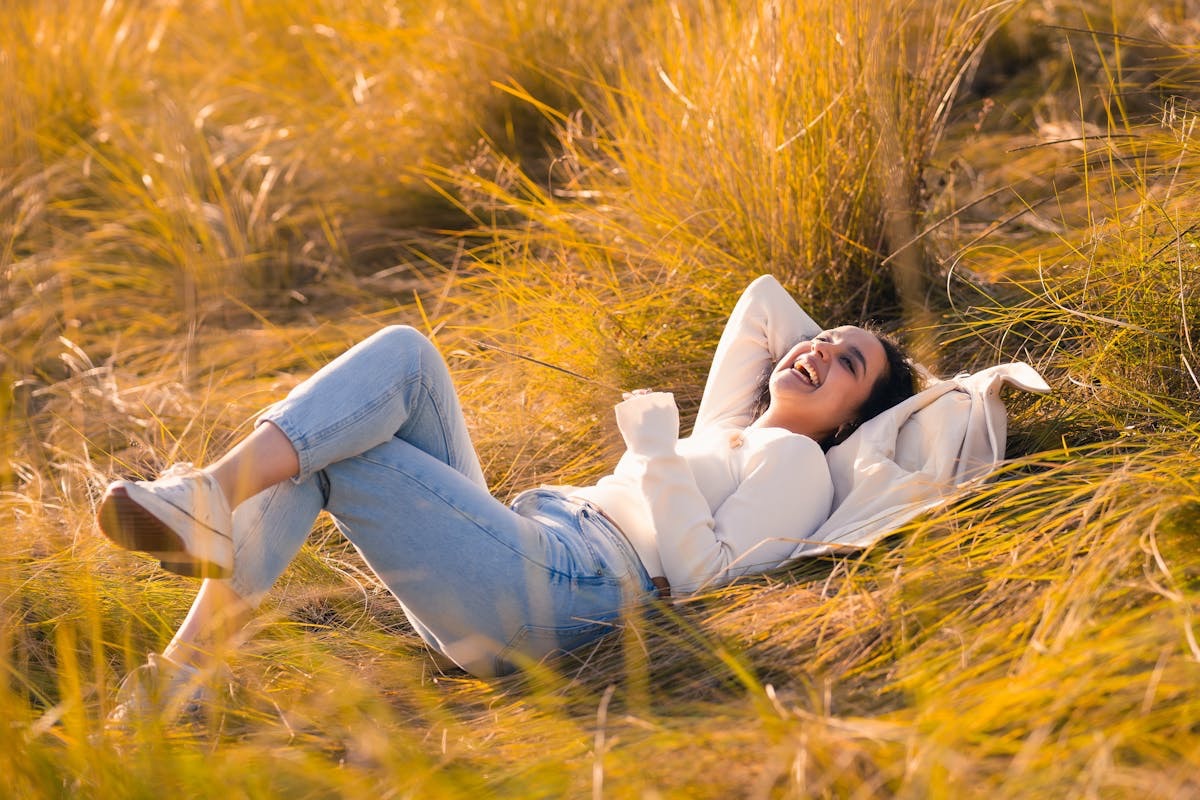 woman reclining in a grassy field, enjoying a sunny day