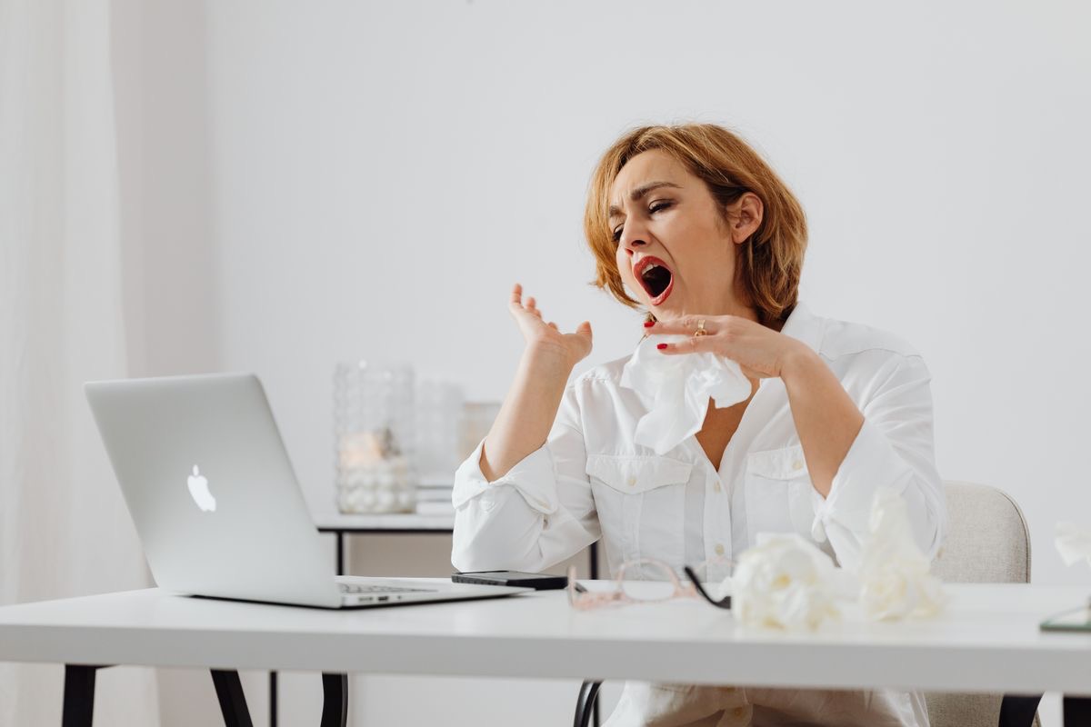 sleepy woman yawning at her desk