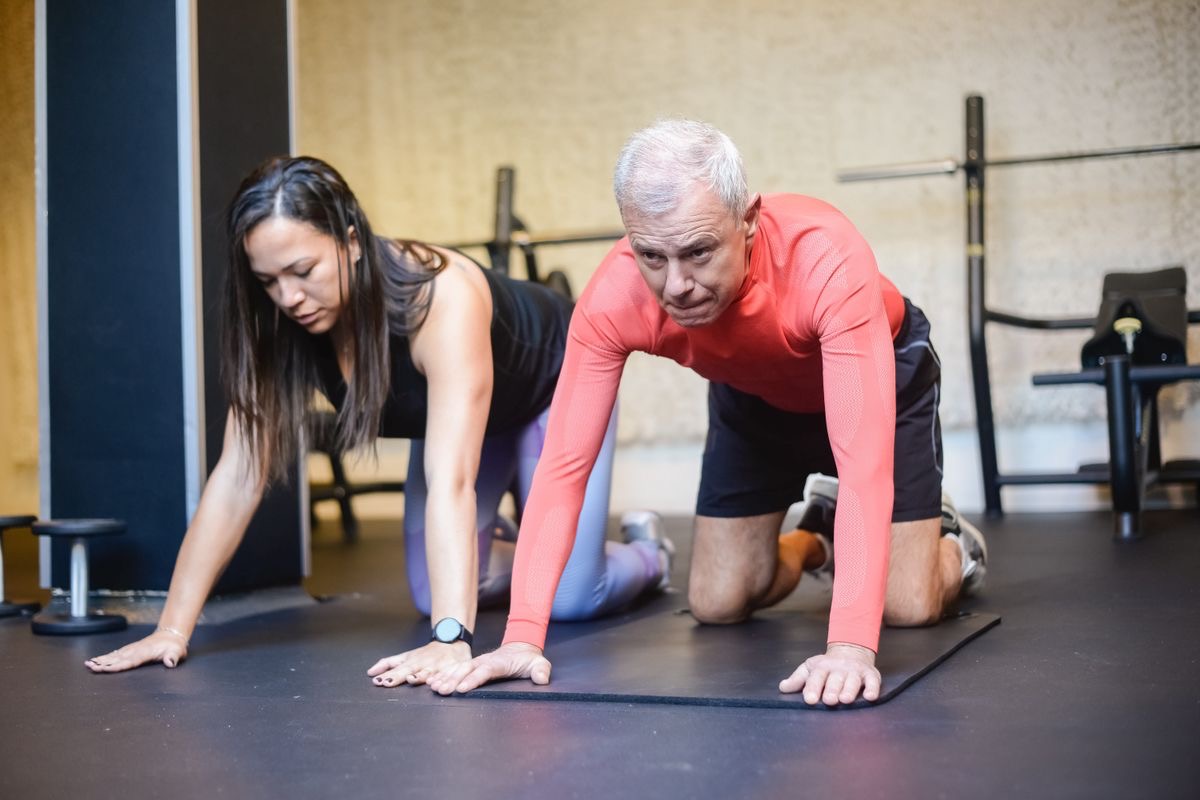 a personal trainer helping an older man reach his fitness goals