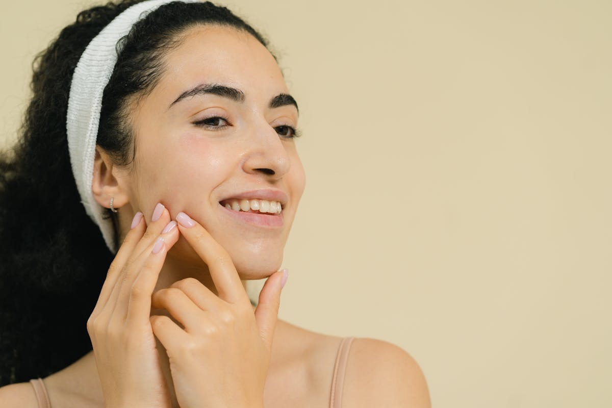 woman admiring her skin, which is smooth and glowing after taking supplements to support skin wellness