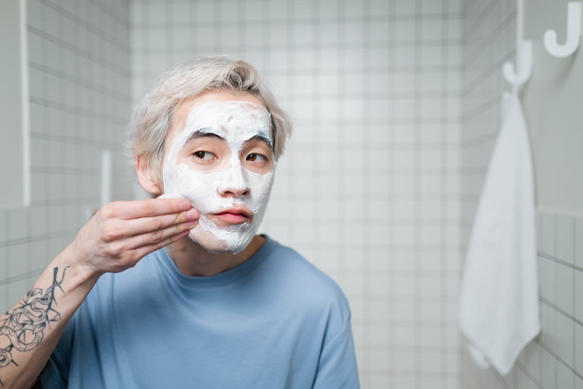 man putting a clay mask on his face to reduce the signs of skin aging