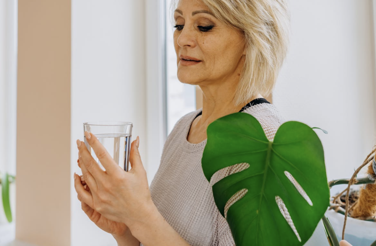 older woman living a healthy lifestyle holding a glass of water