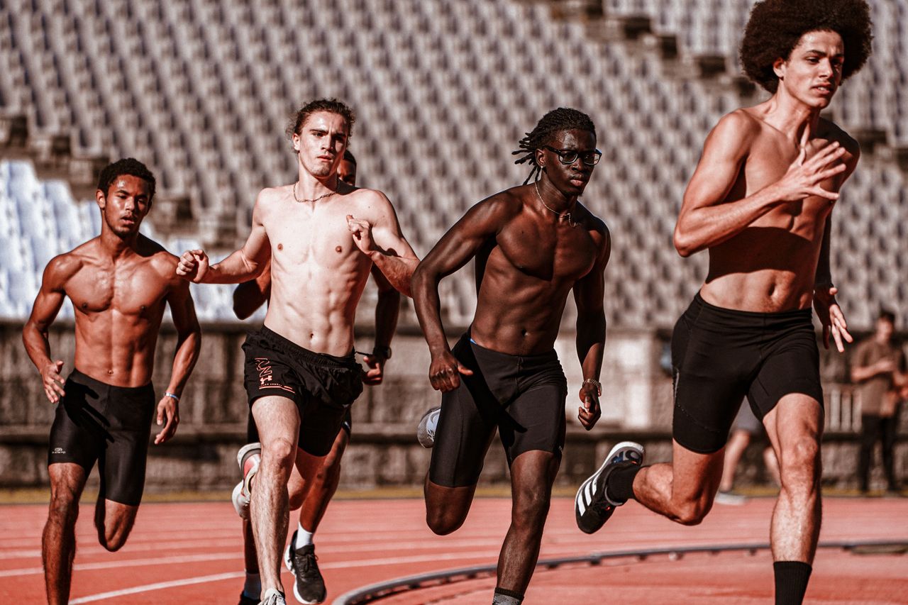 group of athletes running on a track after taking muscle recovery supplements to help prevent injury and allow for more effective training