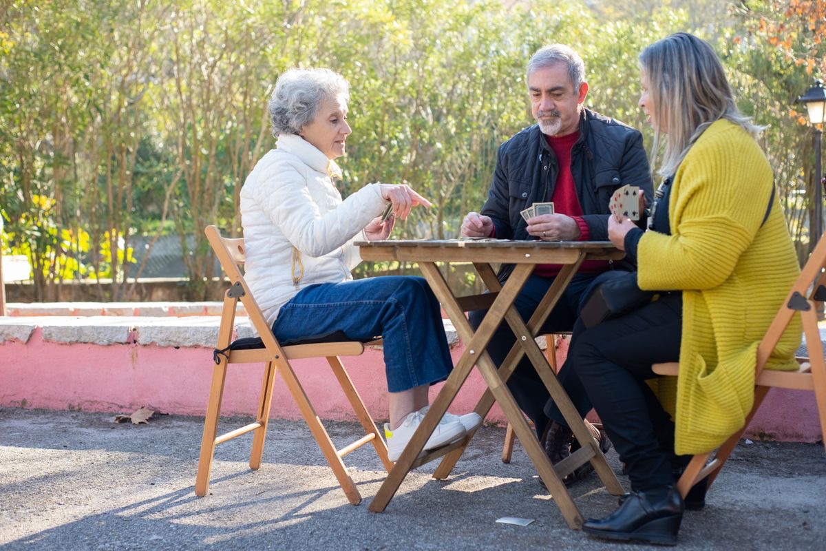 healthy older adults playing cards in the park
