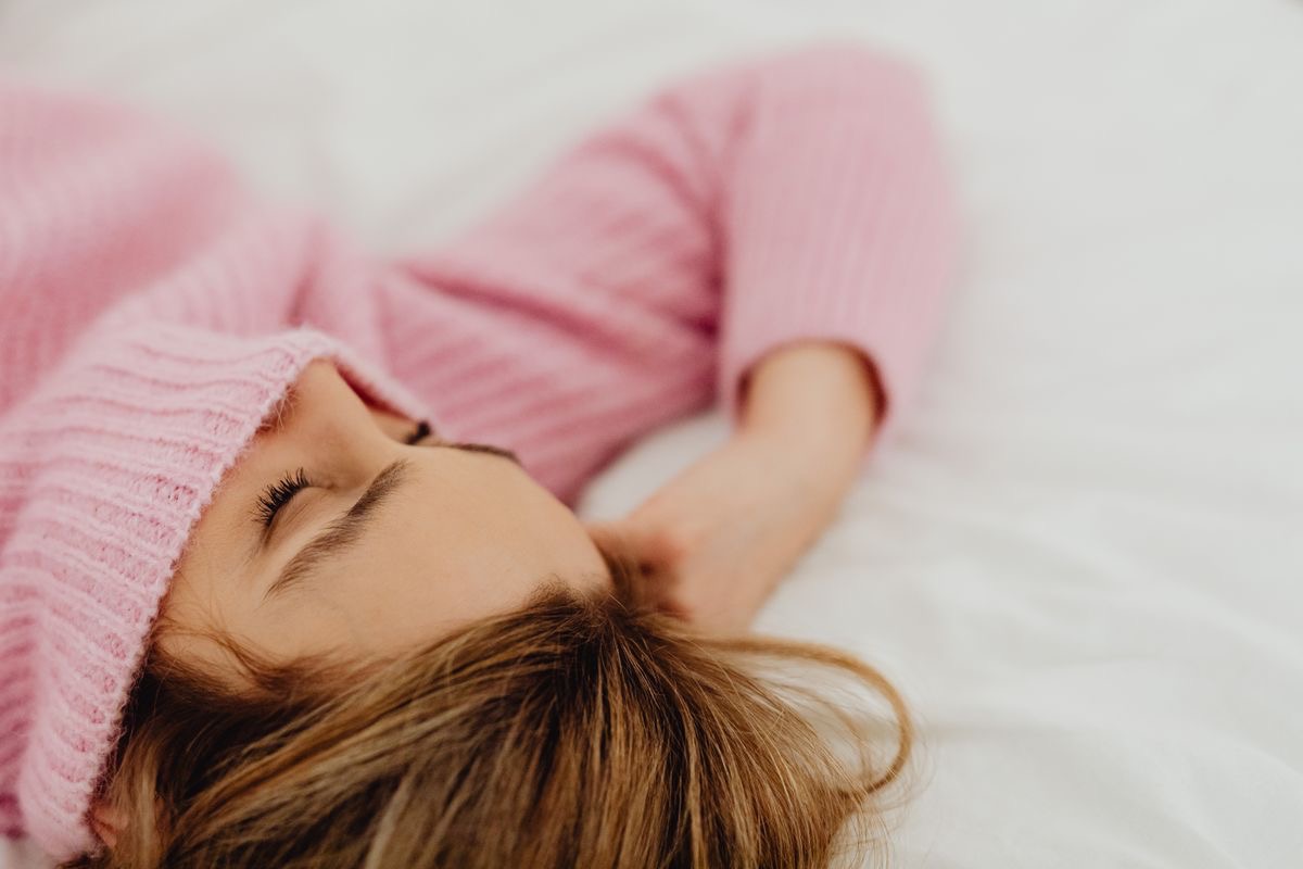 tired woman lying back in a cozy bed