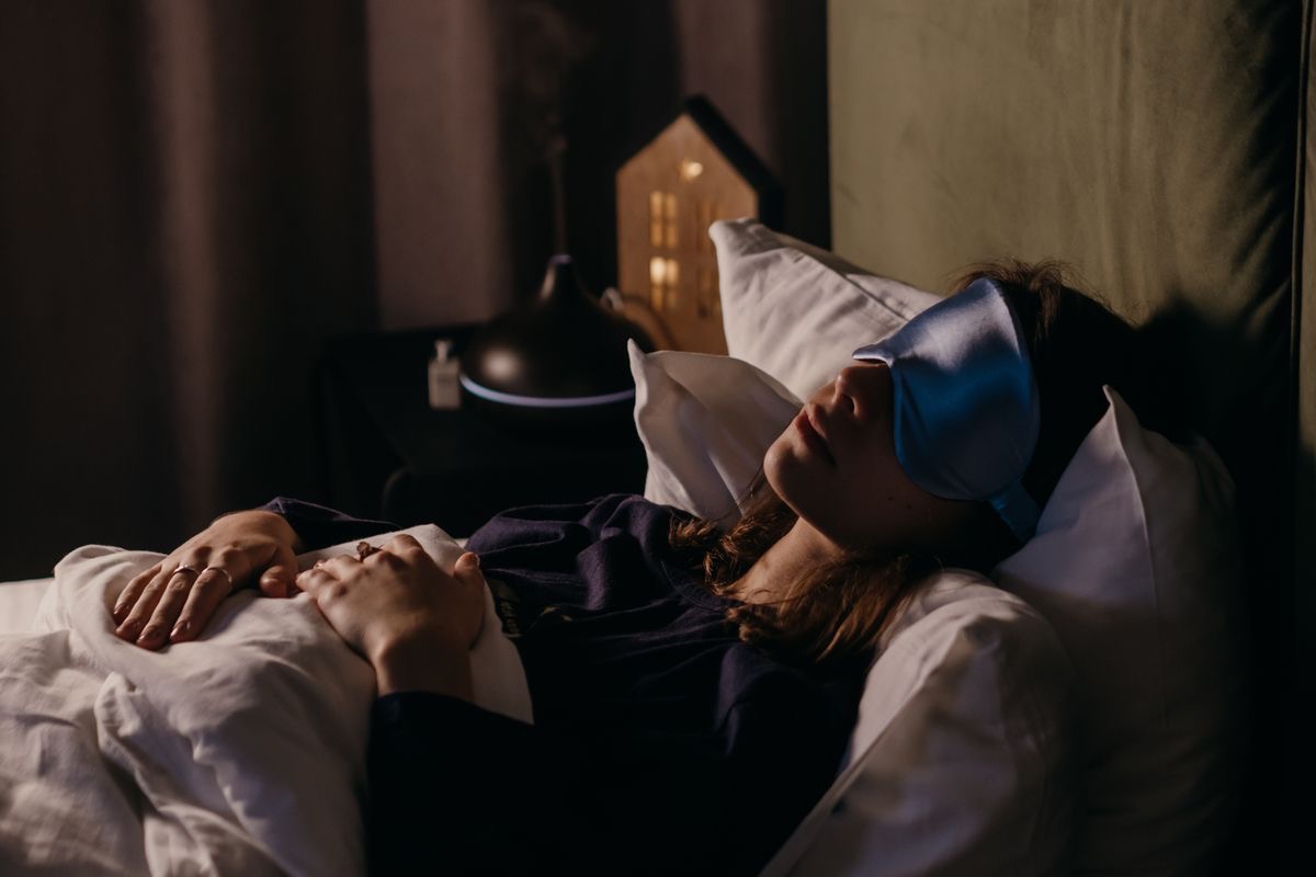 woman wearing a sleep mask lying in bed