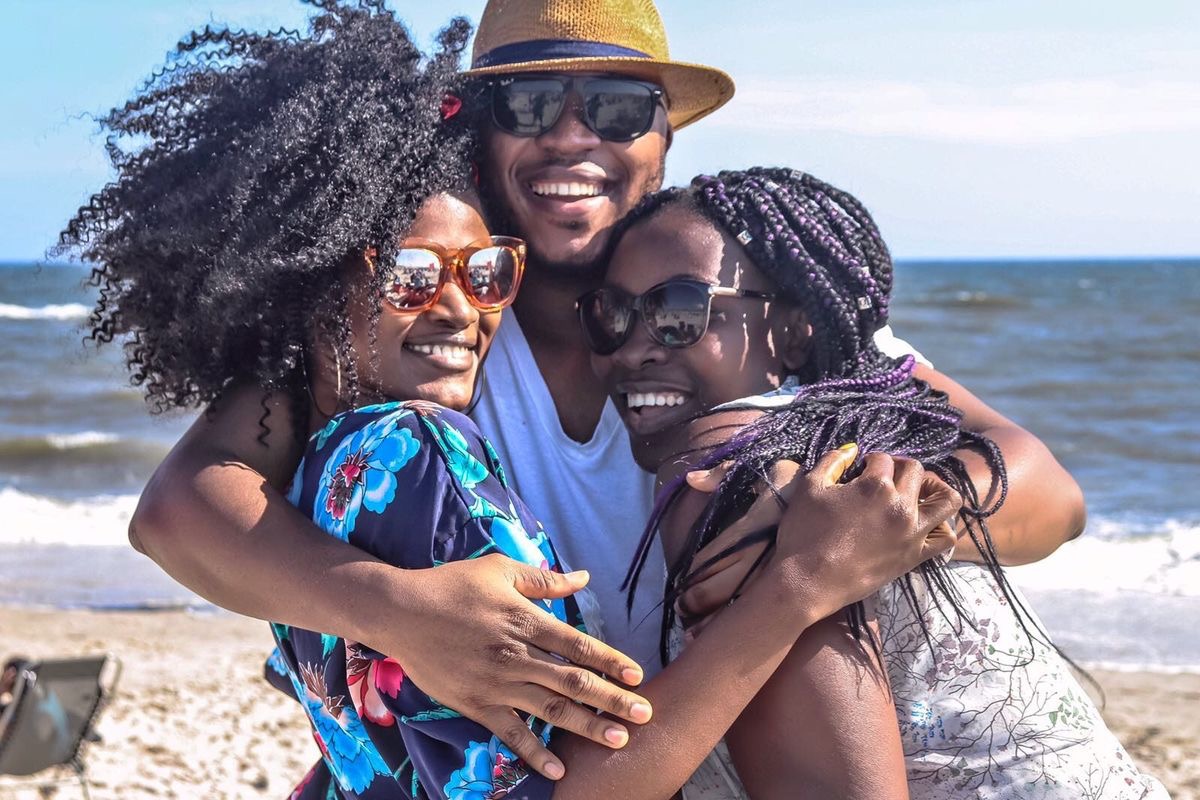family laughing and hugging at the beach