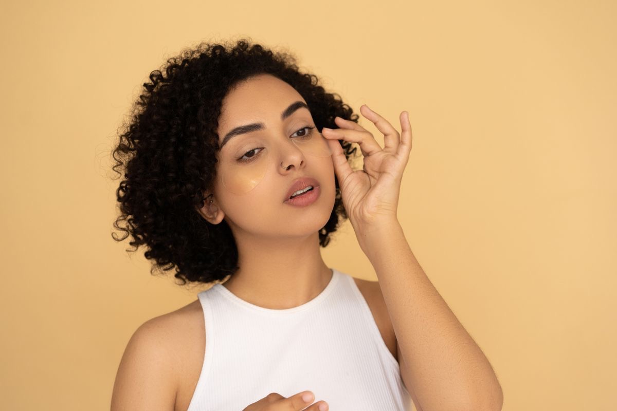 woman touching the skin of her face gently to check its elasticity