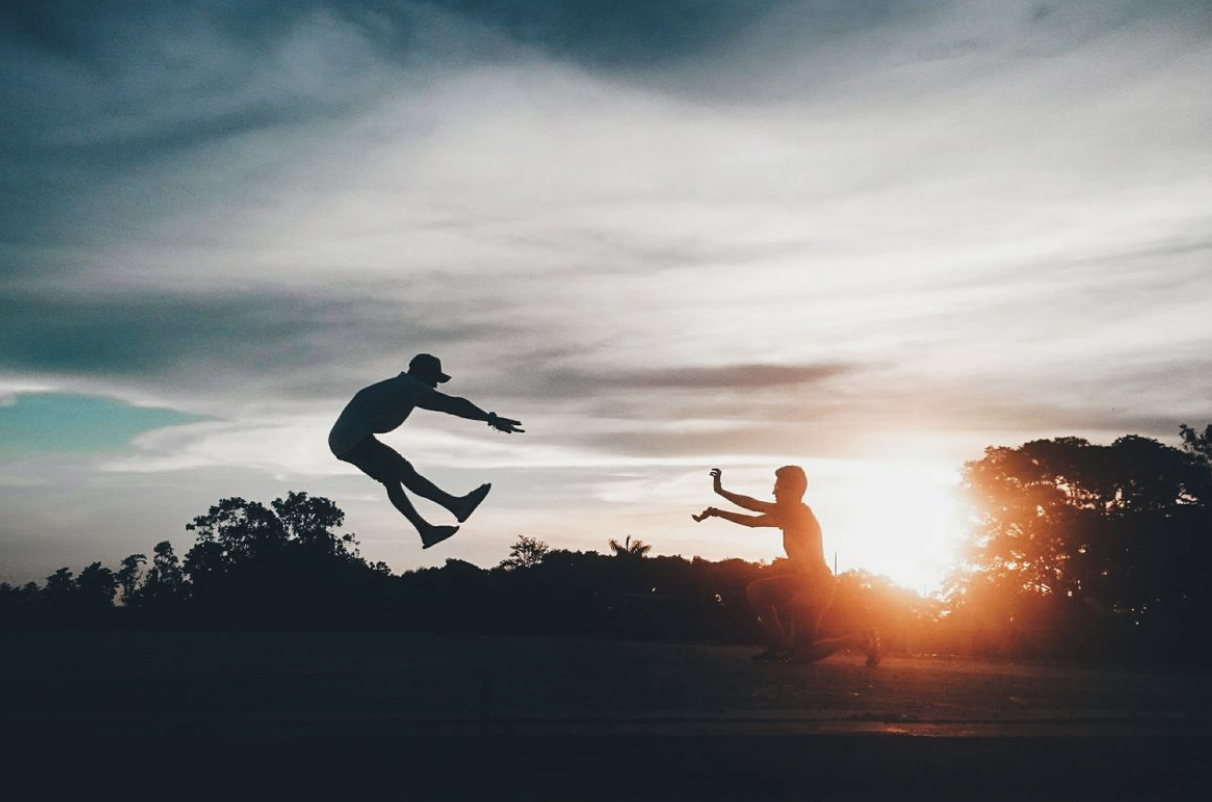 figures leaping energeticlaly in silhouette demonstrating youthful vitality 