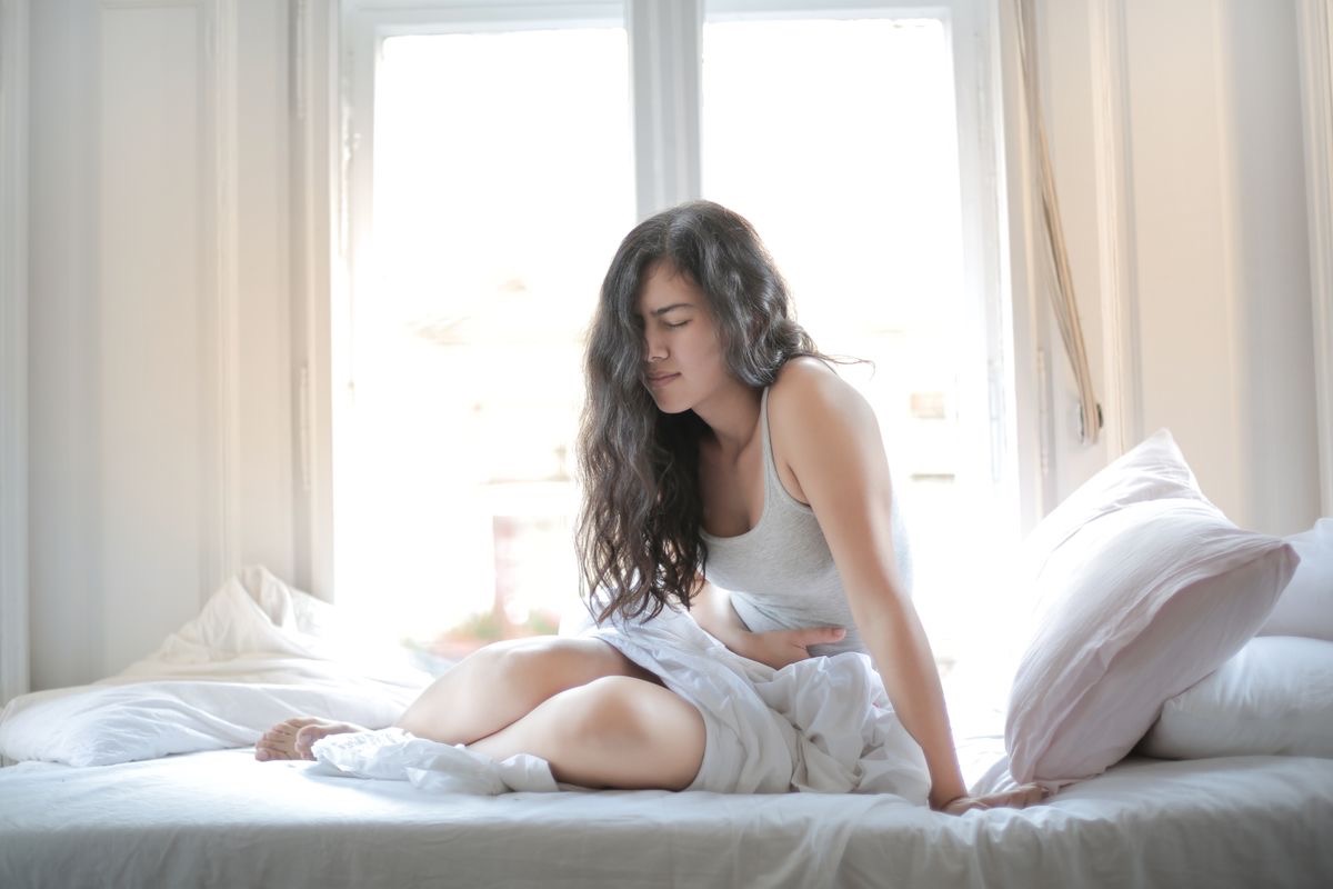 woman with digestive upset resting in a bed