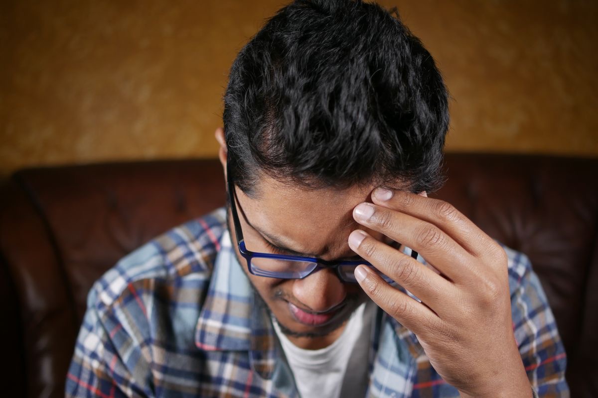 man with brain fog touching his forehead