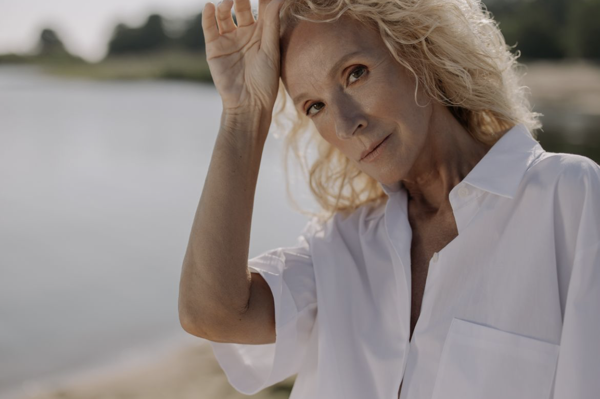 older woman placing a hand on her head as she contemplates how to slow down aging naturally
