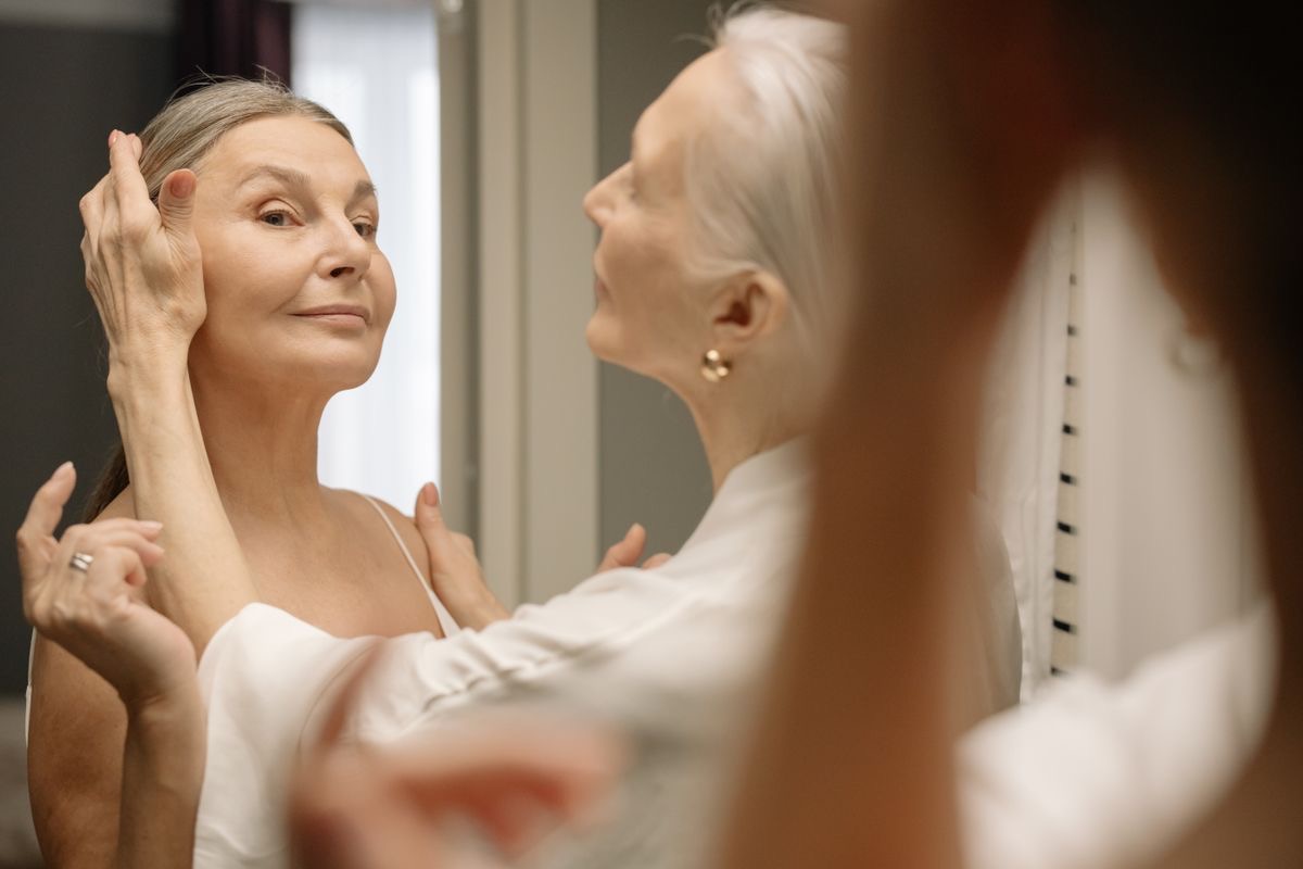 woman tucking an older woman who is aging gracefully's hair behind her ear