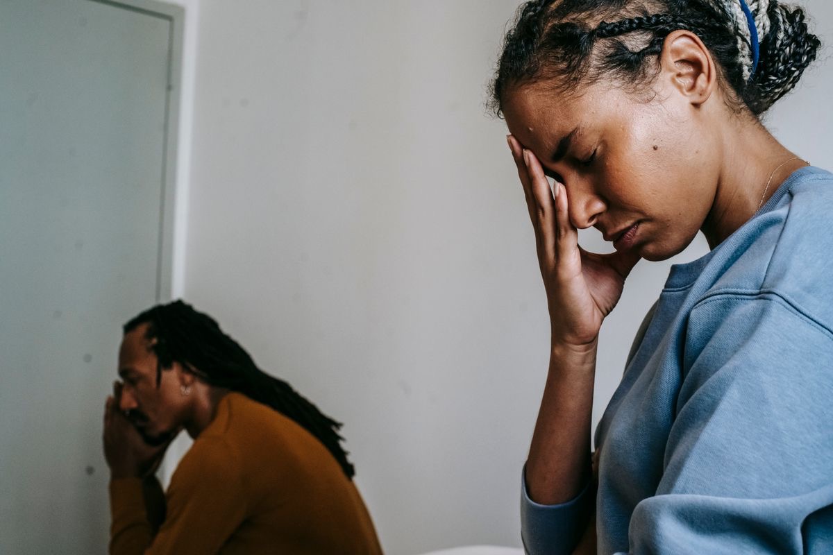 two people holding their heads in their hands to indicate mental health turmoil