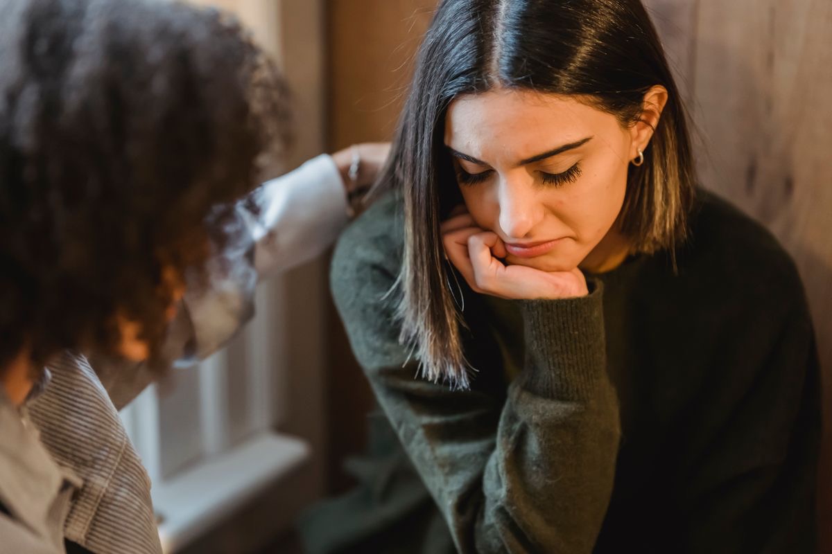 depressed woman talking with a trusted loved one about what she's going through