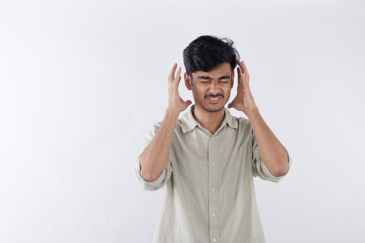 man holding his head in his hands as a gesture of stress