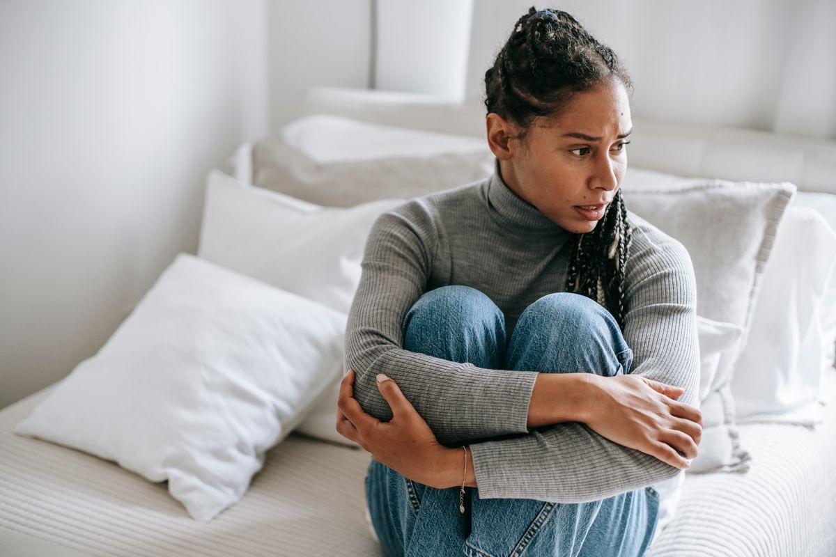 woman whose mood is affected by glp-1 use sitting with her arms wrapped around her knees, looking upset