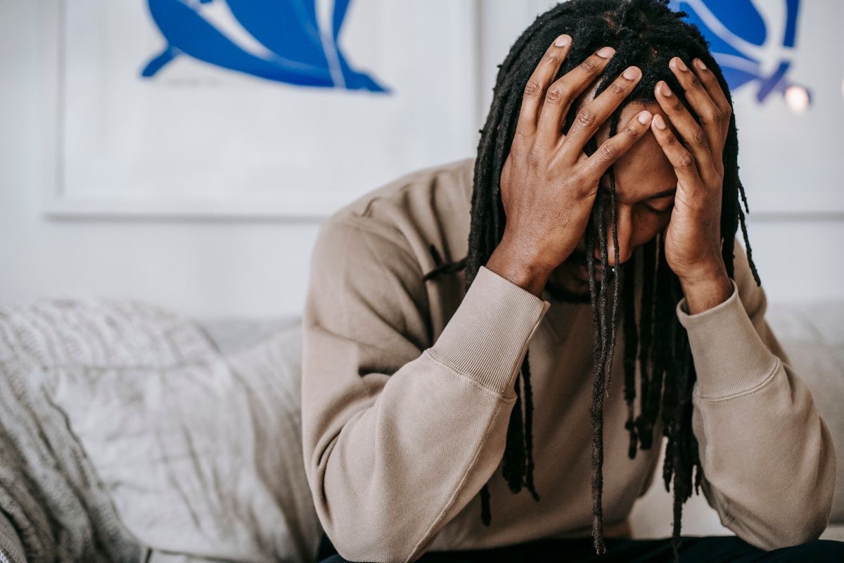 man holding his head in his hands in a gesture of anxiety