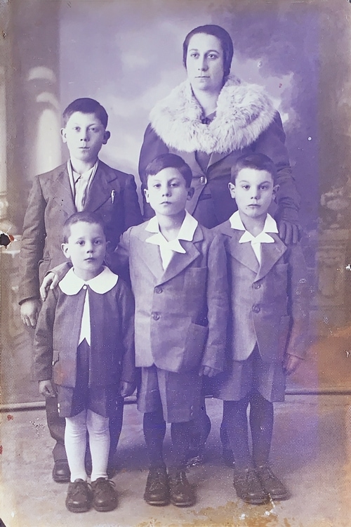 a family from World war 2 standing for a photo, a woman and 4 sons