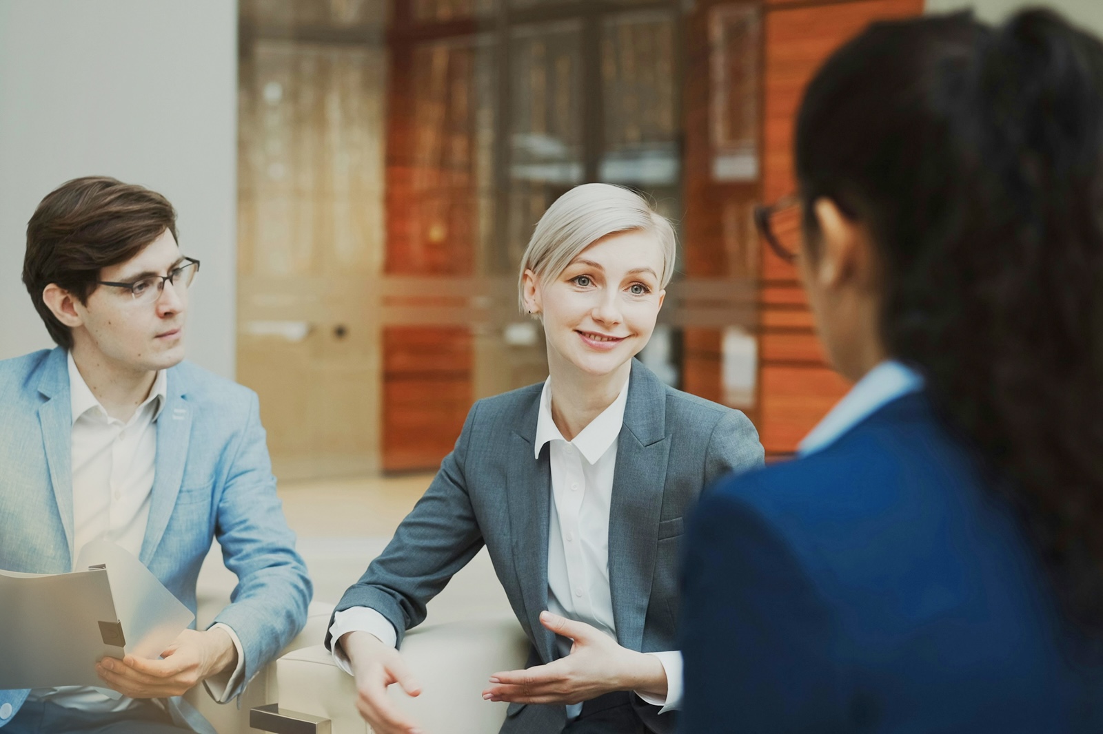Three professionals in a workplace meeting discussing strategy, representing collaboration and decision-making in building workplace resilience.