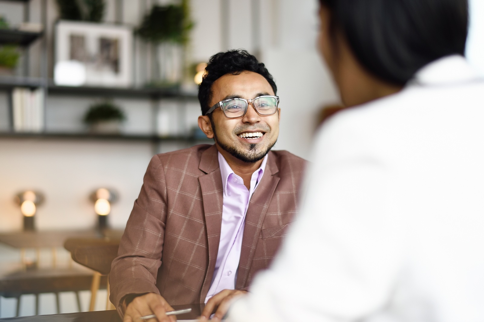 Employee speaking with a colleague in a one-on-one meeting, reflecting integrated support within everyday work