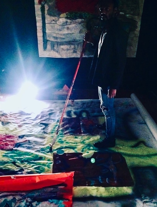 Richie Adomako working on a piece on the floor