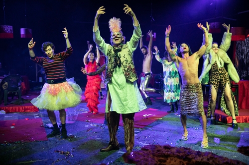 Performers on stage, dancing, in colorful costumes