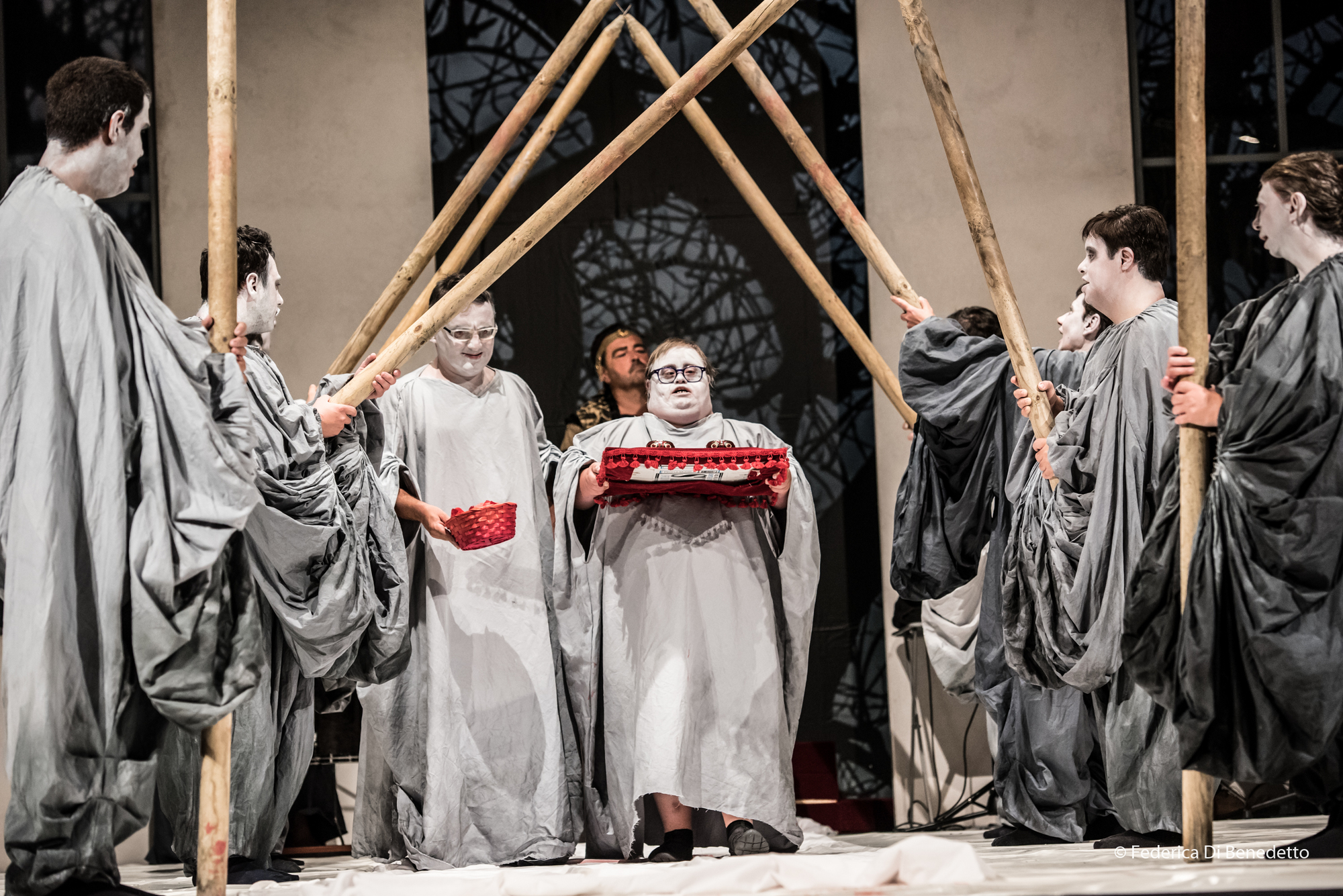 Performers on stage in grey costumes and facepaint