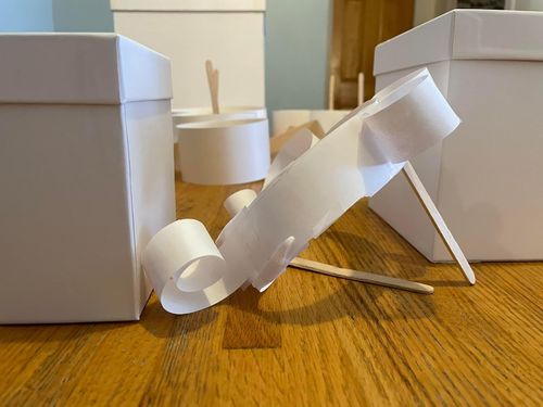 A spiral of paper connected to two popsicle sticks