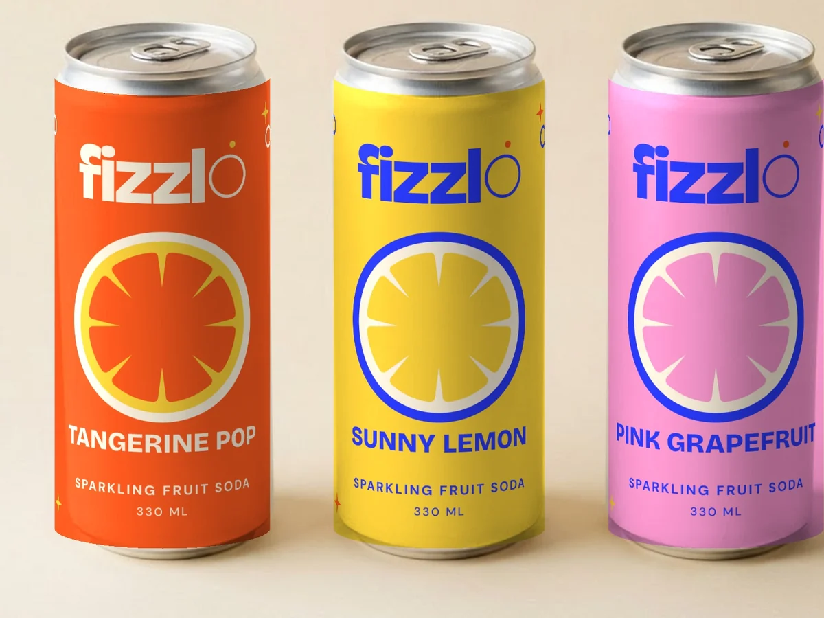 Three Fizzlo cans in tangerine, lemon and grapefruit flavours on a cream backdrop