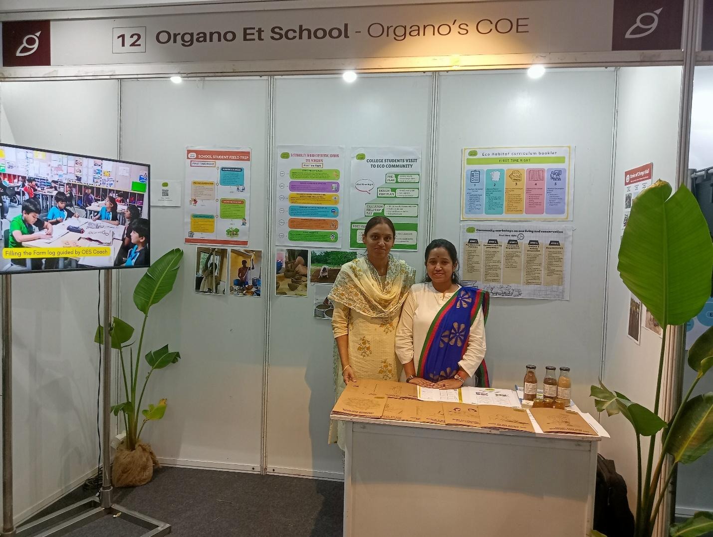 Two women standing in front of a white wallAI-generated content may be incorrect.