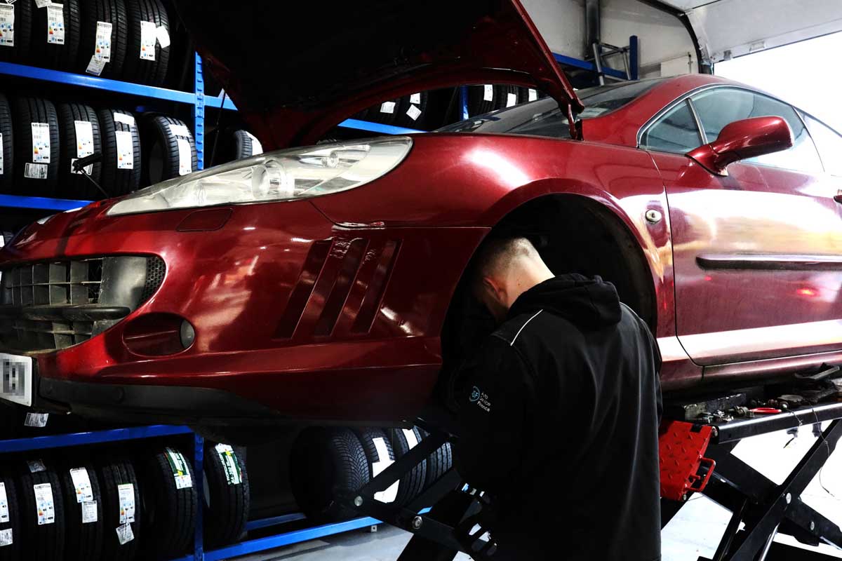 car on ramp with row of tyres behinf