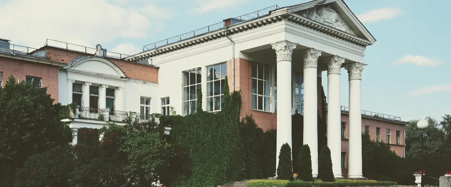 Vista lateral de una enorme casa con columnas altísimas al frente