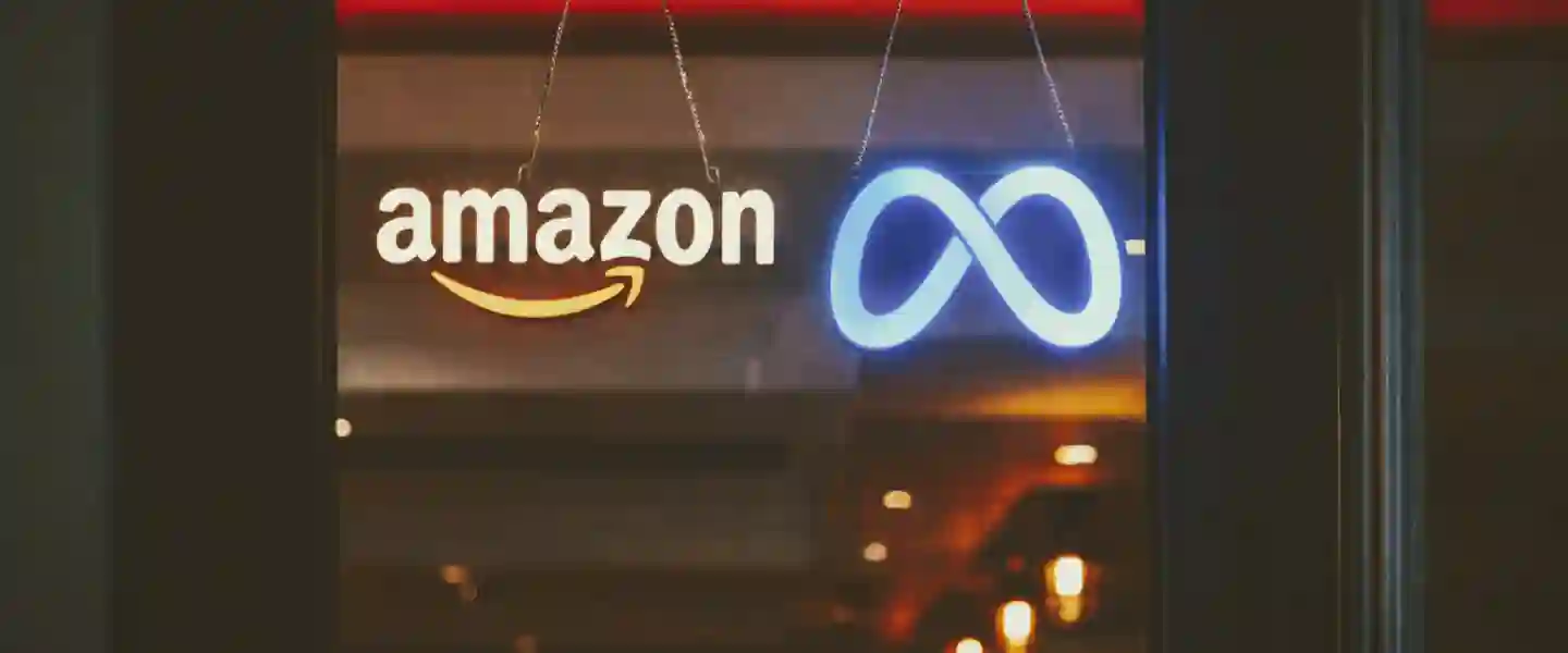 Puerta de una tienda que tiene carteles de neon con los logos de Amazon y Meta